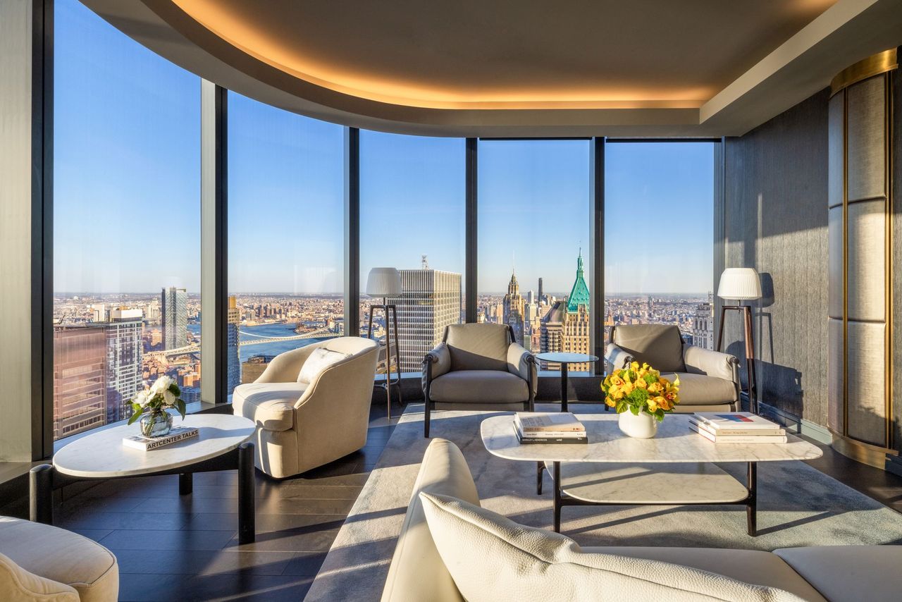 Upscale New York City condo interior with coordinating flower arrangements on tables and NYC skyline visible through background windows